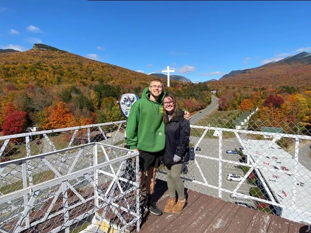 Tyler and his partner overlooking the mountains at the cross