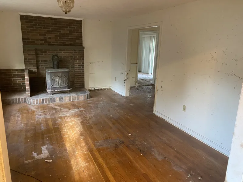 Living room cleared revealing hardwood floors and fireplace