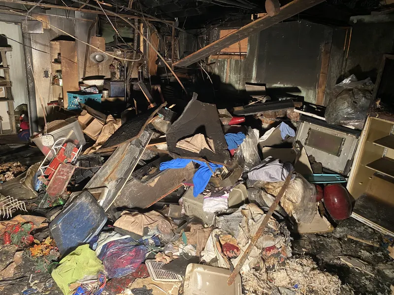 Dark basement filled with debris and discarded items